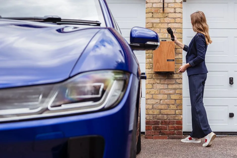 Femme chargeant sa voiture électrique sur une borne domestique, puissance standard 7 kW