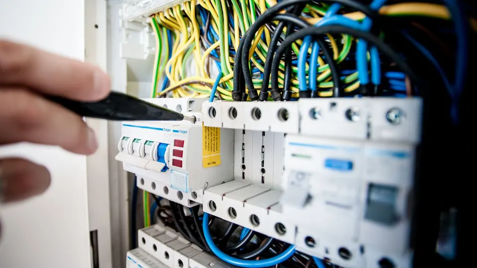 Électricien intervenant sur un tableau de disjoncteurs