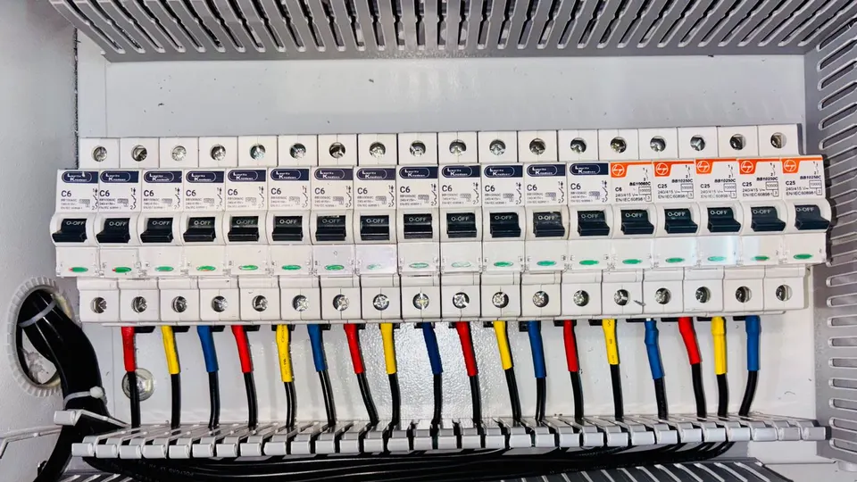 Tableau électrique avec disjoncteurs et câblage repéré par couleurs