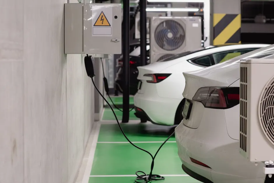 Parking d'immeuble avec borne de recharge murale et véhicules électriques en charge