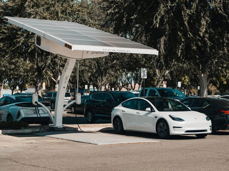 Voiture électrique en charge sur une borne alimentée par des panneaux solaires