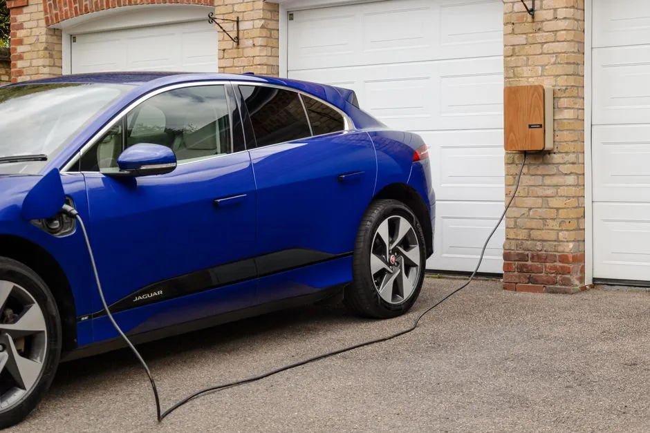 Véhicule électrique en charge sur une borne murale à domicile