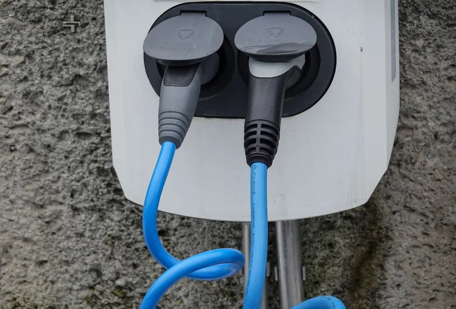 Câbles de recharge d'un véhicule électrique sur une borne, illustrant le temps de charge selon la puissance